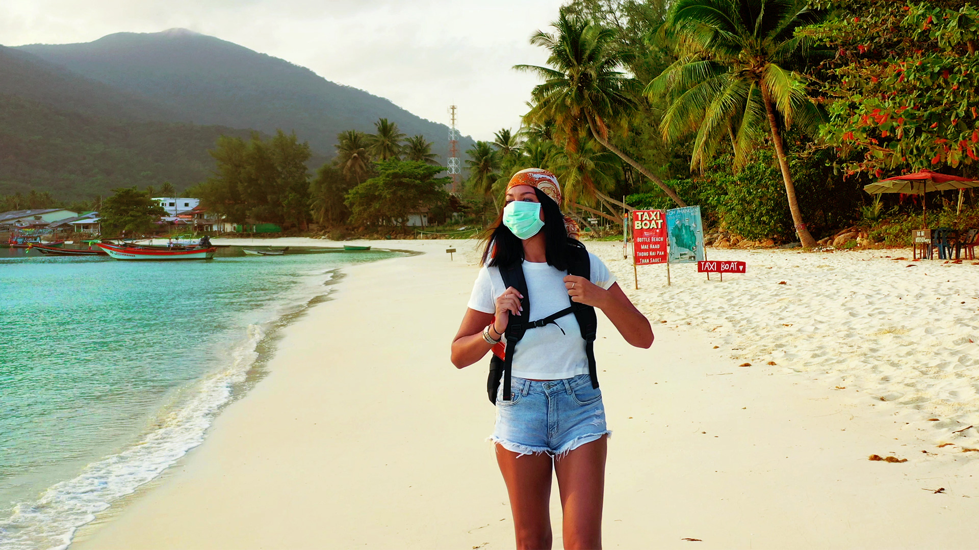 mulher caminhando em praia paradisíaca com máscara azul